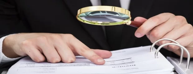 auditor financiero revisado con lupa documentos